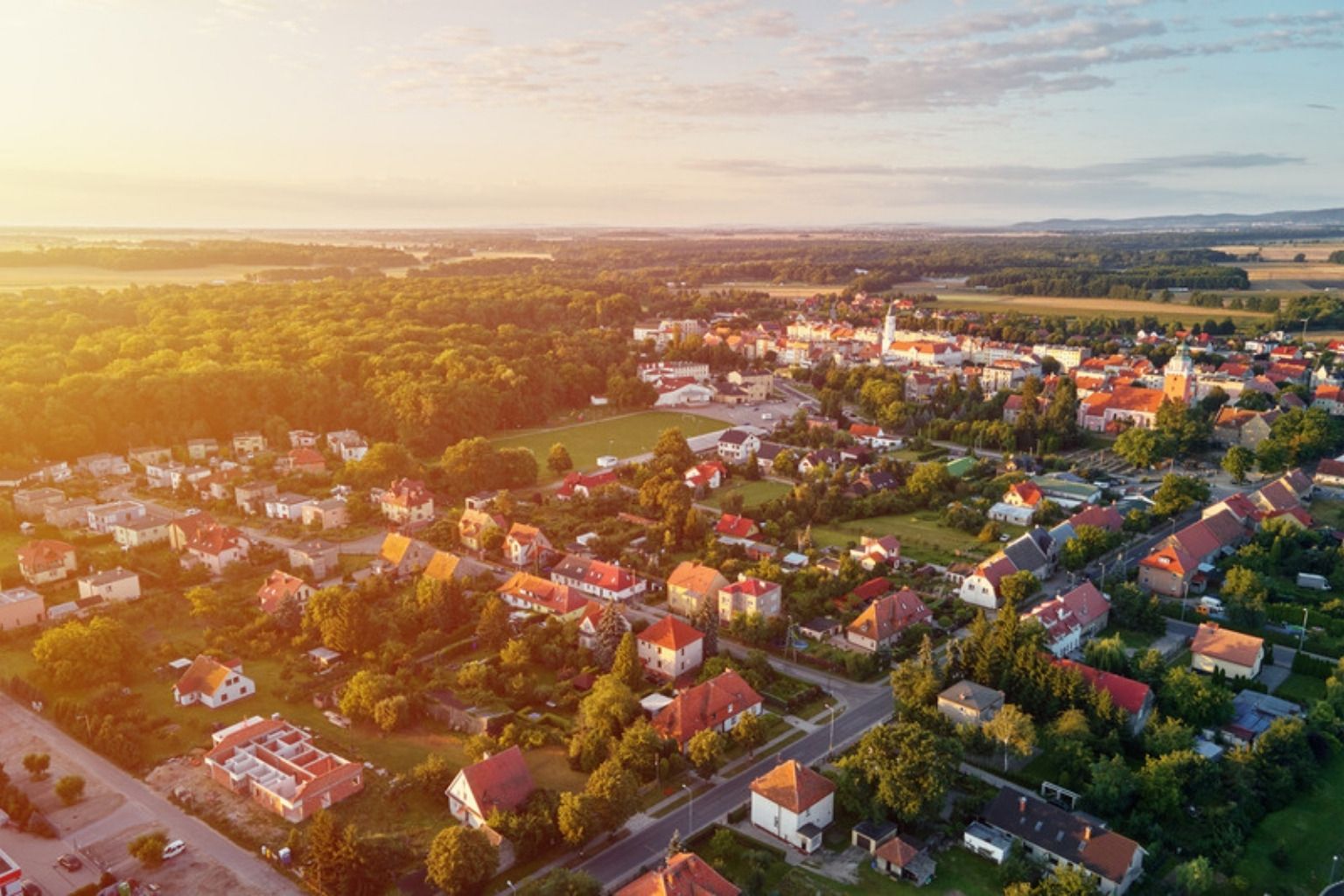 Luftfoto af by og villakvarter i aftensol